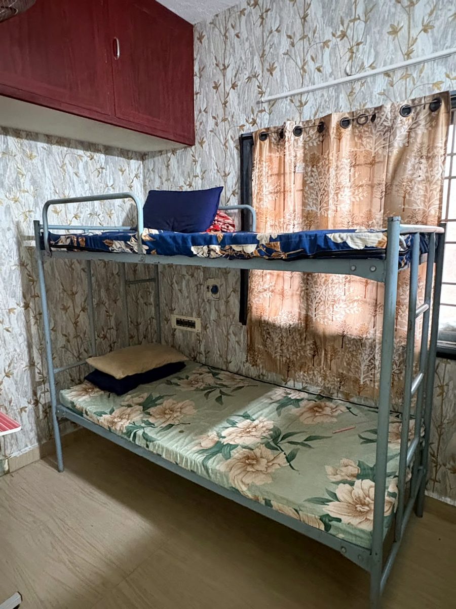 Bunk cot in a wallpapered room
